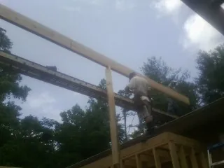 Carpenter setting a ridge beam over a new addition frame — Ice Dam Removal by Roofing Brothers in Lagrangeville