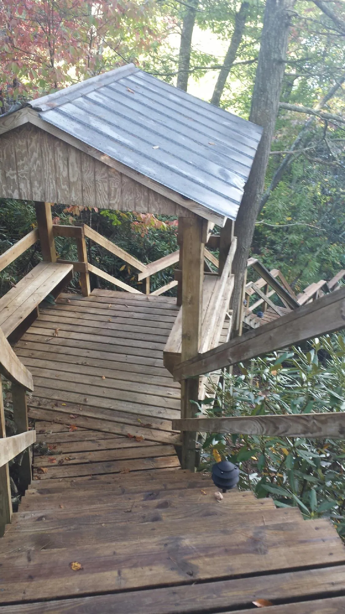 Metal roofed shelter over wooden steps on a wooded walkway — Skylight Repair & Installation work by our crew in Lagrangeville