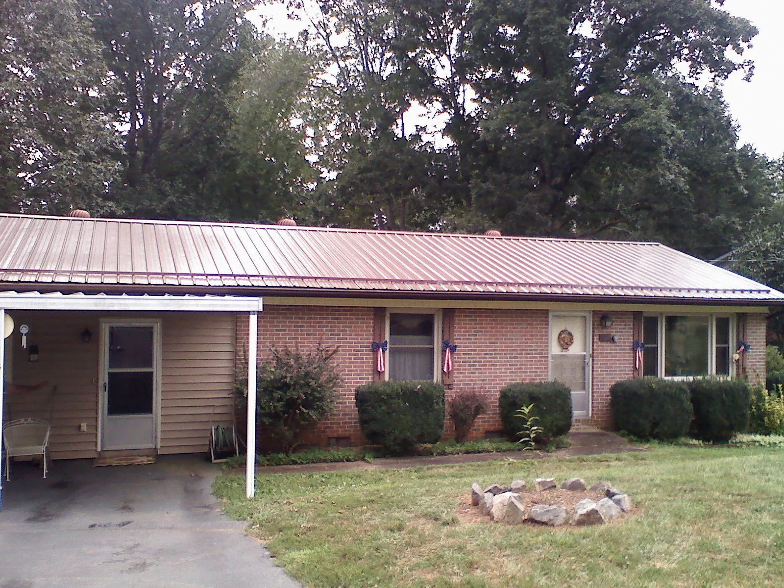 Bronze metal roof and carport on a brick ranch home — Roof Repair work by our crew in Lagrangeville